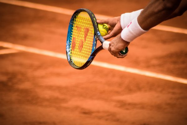 close-up-photo-of-person-holding-tennis-racket-and-ball-1432039